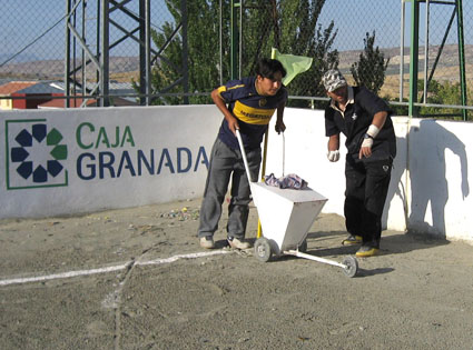 Colaboradores pintanto el campo antes del encuentro