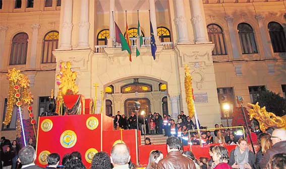 La carroza del rey Gaspar, de vuelta ya vacía, pasa delante del Ayuntamiento con las banderas a media asta